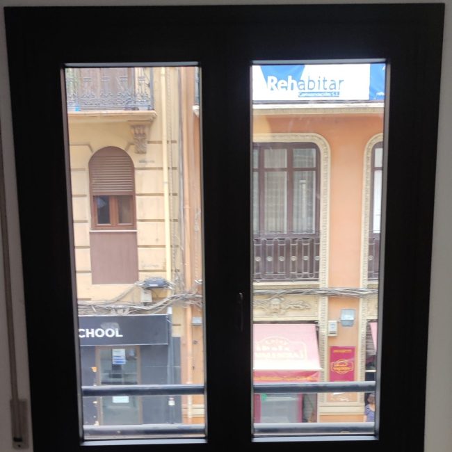 Ventana con dos hojas tipo puerta, de color negro