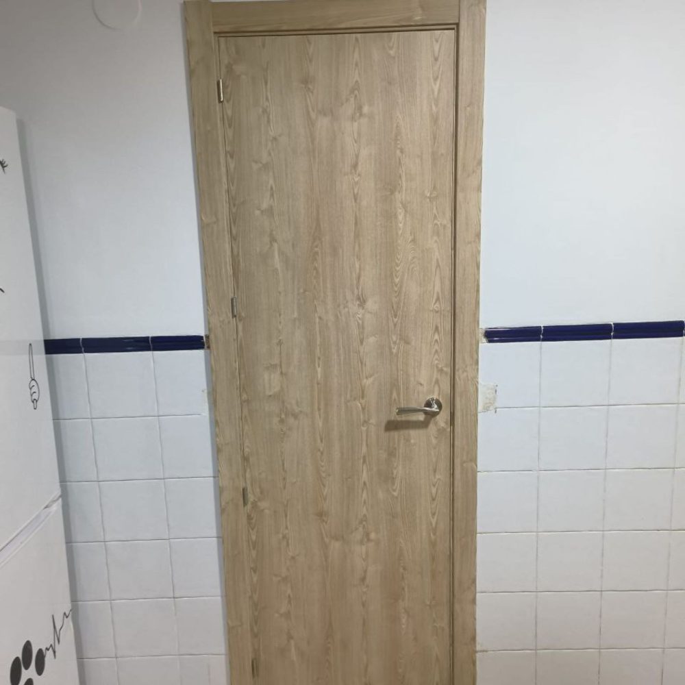 Misma puerta clara de madera, pero desde el otro lado